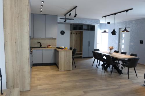 a kitchen and dining room with a table and chairs at Avangard HOME II in Rokovci