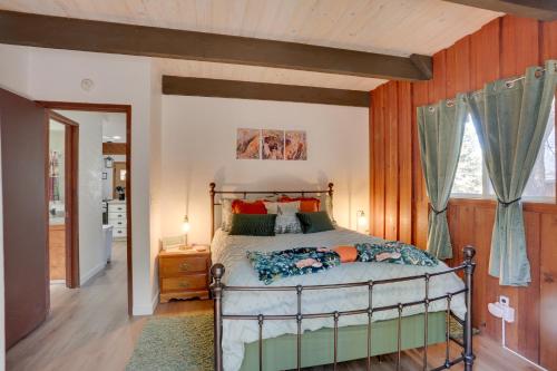 een slaapkamer met een bed en een houten muur bij Sherwood Cabin with Deck, Fire Pit and Lake Access! in Big Bear City