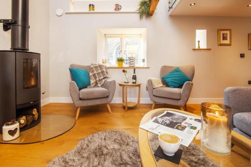 sala de estar con estufa de leña y 2 sillas en 1 Castle Mews, en Dartmouth