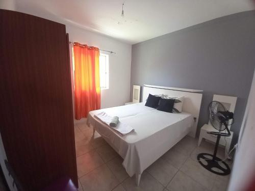 ein Schlafzimmer mit einem weißen Bett und einem Fenster in der Unterkunft Casa Barreto in Tarrafal