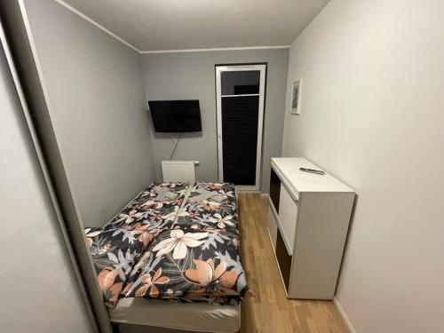 a small bedroom with a bed and a desk at Apartament Głowackiego 10 in Koszalin