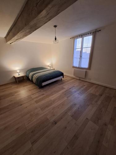 1 dormitorio con cama y ventana grande en Le val d Arlette, en Arsonval