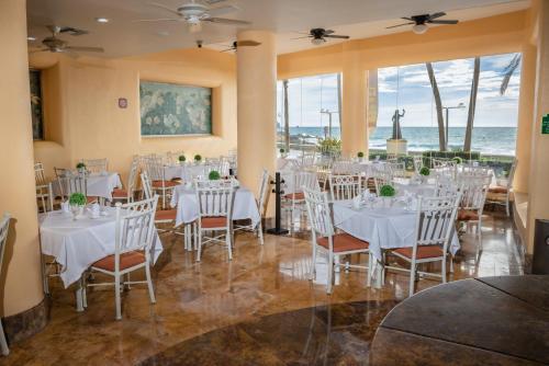 a dining room with white tables and chairs at Best Western Posada Freeman in Mazatlán