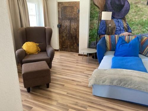 a living room with a couch and a chair at Haus Buckaroo – Rancho el Rosal in Bad Mergentheim
