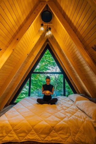 a man sitting on a bed in a room with a window at bungalov in Sapanca