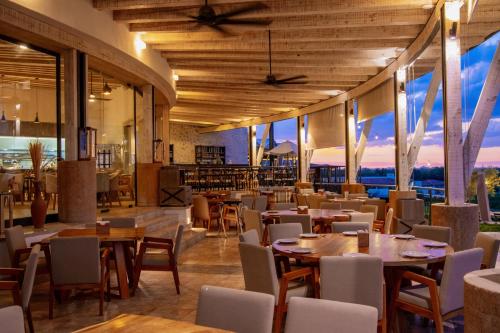 - un restaurant avec des tables et des chaises offrant une vue dans l'établissement Hotel Vinícola Parvada by Lumina, à Parras de la Fuente
