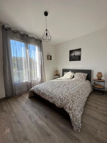 - une chambre avec un lit et une grande fenêtre dans l'établissement Arlette, à Ouistreham
