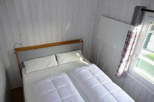 a bed with two pillows in a room with a window at Ferienhaus Bergblick in Meschede