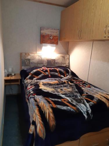 een slaapkamer met een bed met een deken erop bij Peace and Quiet in Lac La Biche