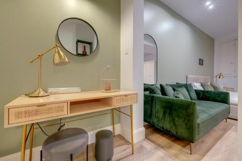a living room with a green couch and a mirror at Tranquil Studio in the Heart of Valletta in Valletta