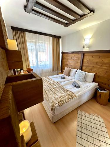 a bedroom with a large bed and a window at Red House Family Hotel in Bansko