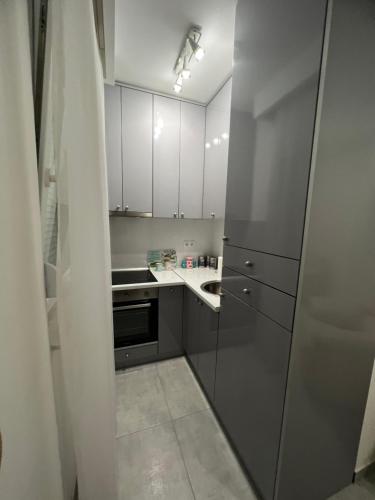 a small kitchen with white cabinets and a sink at Apartman Ružica2 in Bijeljina