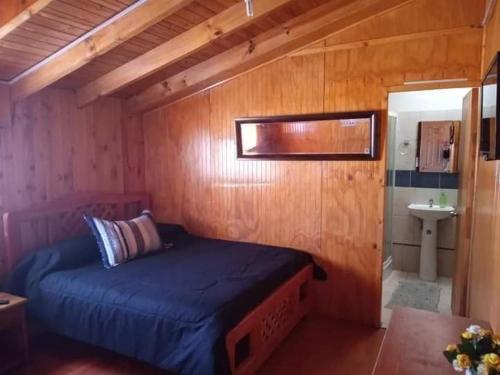 Dormitorio pequeño con cama y lavamanos en OCEANO HOSTEL, en Pichilemu