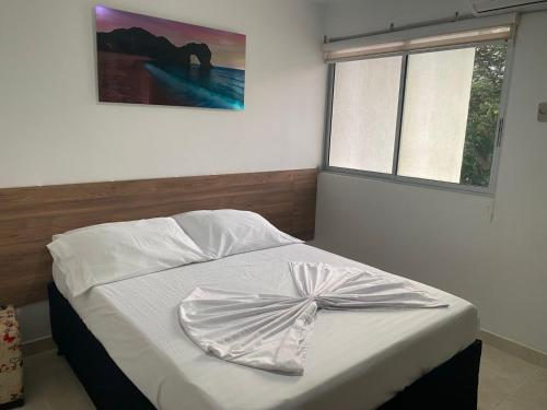 a bed with a dress on it in a bedroom at Apartamento en Condominio in San Jerónimo
