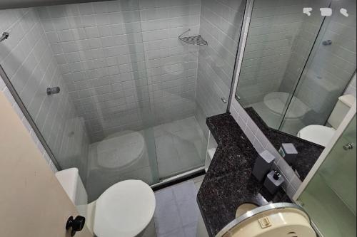 a bathroom with a toilet and a glass shower at Loc10flats 3 Quartos - Residencial Monte Castelo in Bezerros