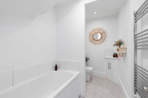 baño blanco con bañera y aseo en Stylish Three Bedroom Period Home, 
