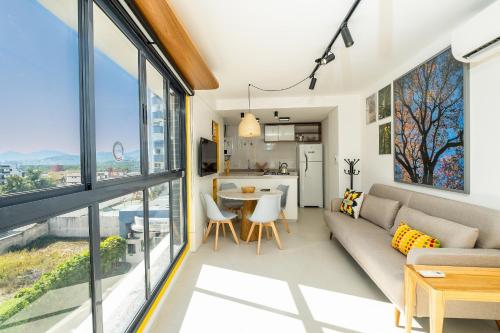 un soggiorno con divano e tavolo di Belíssimo e moderno studio para casais STU309 a Florianópolis