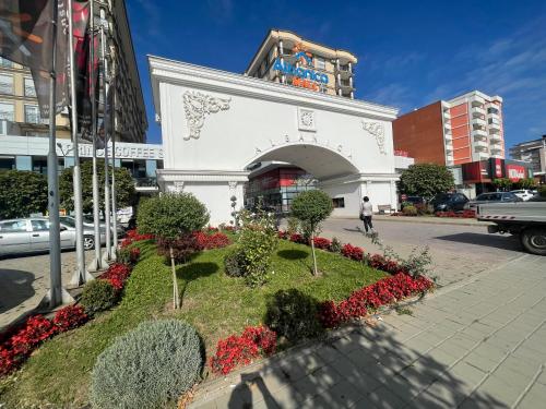 a white building with a flower garden in the street at Sonny’s Penthouse in Gjilan