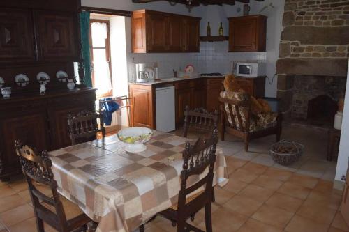 une cuisine avec une table et des chaises et une cuisine avec une cheminée dans l'établissement La Forêt Auvray - Maison de campagne, à Putanges