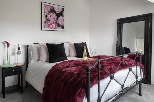 a bedroom with a bed with a red blanket at Spacious and modern family apartment, central and within walking distance to local amenities in Abergele