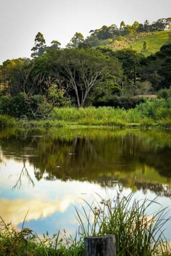 a body of water with trees in the background at Recanto dos Beija Flores, Chalé lantana a in Monte Alegre do Sul
