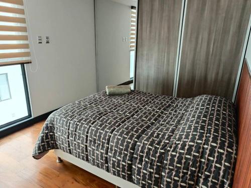 ein Schlafzimmer mit einem Bett mit einer Bettdecke darauf in der Unterkunft Espectacular Dpto. 2D(cala coto) in La Paz