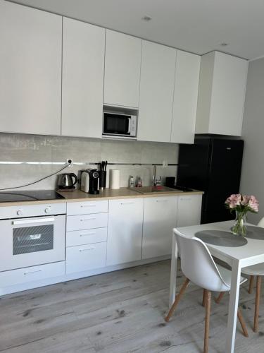 a kitchen with white cabinets and a table and a table and chairs at Apartament na Dworcowej Centrum in Wrocław