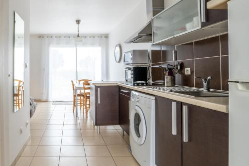 une cuisine avec un évier et un lave-vaisselle dans l'établissement Logement thermale et de tourisme Les Acacias 4, à Jonzac