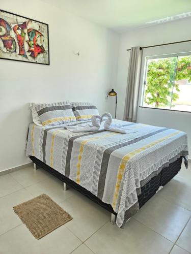 Ce lit se trouve dans un dortoir blanc doté d'une fenêtre. dans l'établissement Cantinho do Atalaia à 650 metros da praia - Seu conforto fora de casa, à Salinópolis