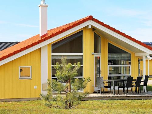 ein gelbes Haus mit einem Tisch und Stühlen in der Unterkunft 6 person holiday home in Gro enbrode in Großenbrode