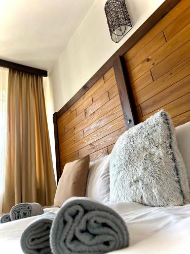 a bedroom with a bed with a wooden headboard at Red House Family house in Bansko