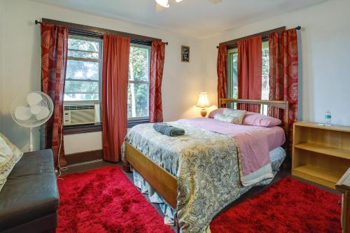 a bedroom with a bed and windows with red curtains at Pet-Friendly Pittsburgh Home about 9 Mi to Downtown! in Pittsburgh