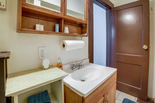 La salle de bains est pourvue d'un lavabo blanc et d'une porte marron. dans l'établissement Pet-Friendly Pittsburgh Home about 9 Mi to Downtown!, à Pittsburgh