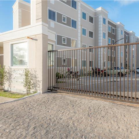 a large building with a gate in front of it at Pedacinho de Lar in João Pessoa