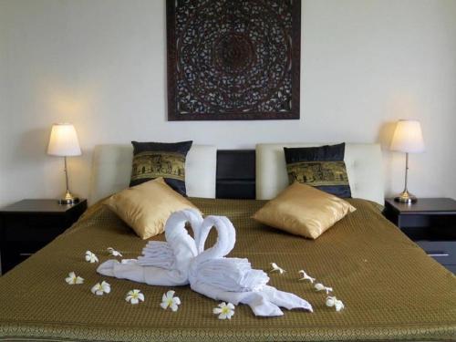 two swans made out of towels on a bed at Viking House Villa Deluxe in Koh Tao