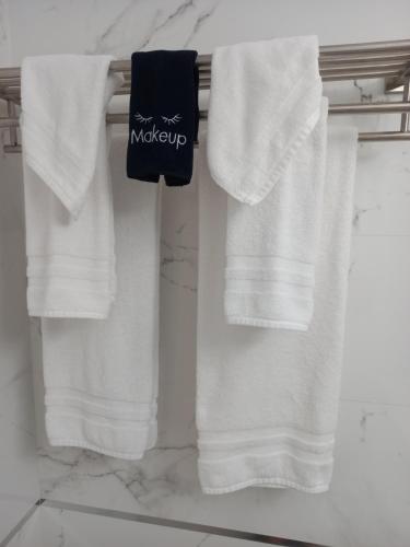 three white towels on a towel rack in a bathroom at Marchabell by the Sea E22 in Ocho Rios