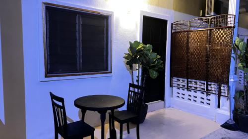 a small table and chairs in a room with a window at Rerama Room Stay Langkawi in Pantai Cenang