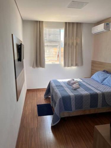 a hotel room with a bed and a window at Suite Montmartre in Lagoa Santa