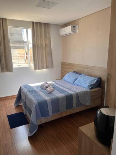 ein Schlafzimmer mit einem Bett mit einer blauen und weißen Decke in der Unterkunft Suite Montmartre in Lagoa Santa