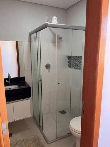 a bathroom with a shower and a toilet and a sink at Suite Montmartre in Lagoa Santa