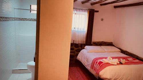 Un dormitorio con una cama con dos muñecas. en Mirador inka, en Ollantaytambo