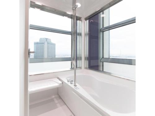 a bathroom with a tub and a window at Sakishima Cosmo Tower Hotel - Vacation STAY 01082v in Osaka