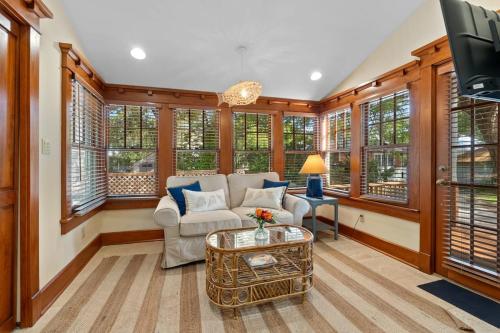 a living room with a couch and a tv at Flagler Cottage - 1 Block to Historic District in St. Augustine