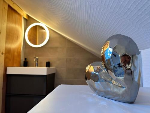 una escultura de metal sentada en una mesa en un baño en Le trésor de Khalis en Colmar