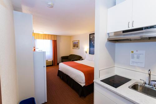 a hotel room with a bed and a sink at Super 8 by Wyndham Drayton Valley in Drayton Valley