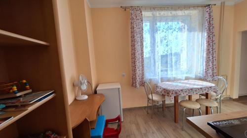 małą kuchnię ze stołem i oknem w obiekcie Mieszkanko na peryferiach w mieście Chrzanów