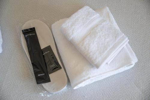 sandały i ręcznik na stole w obiekcie Nesto Athens Airport w mieście Spata