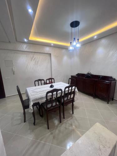 a dining room with a table and chairs and a piano at Luxury Center Town Apartment in Kenitra