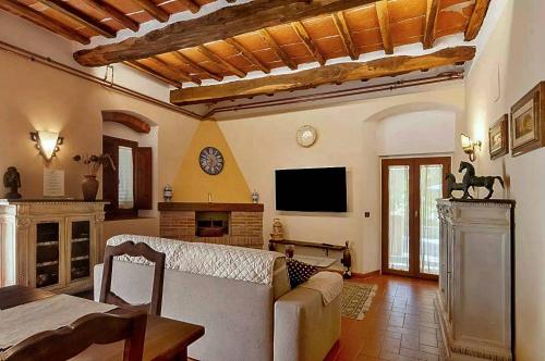 a living room with a couch and a tv at Holiday Home Villa il Cesto in Greve in Chianti
