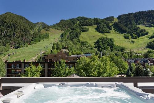 a hot tub with a view of a mountain at Independence Square 210, Beautiful Studio with Kitchenette, Great Location in Downtown Aspen in Aspen
